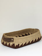 Woven basket with a leather strap on a light gray background