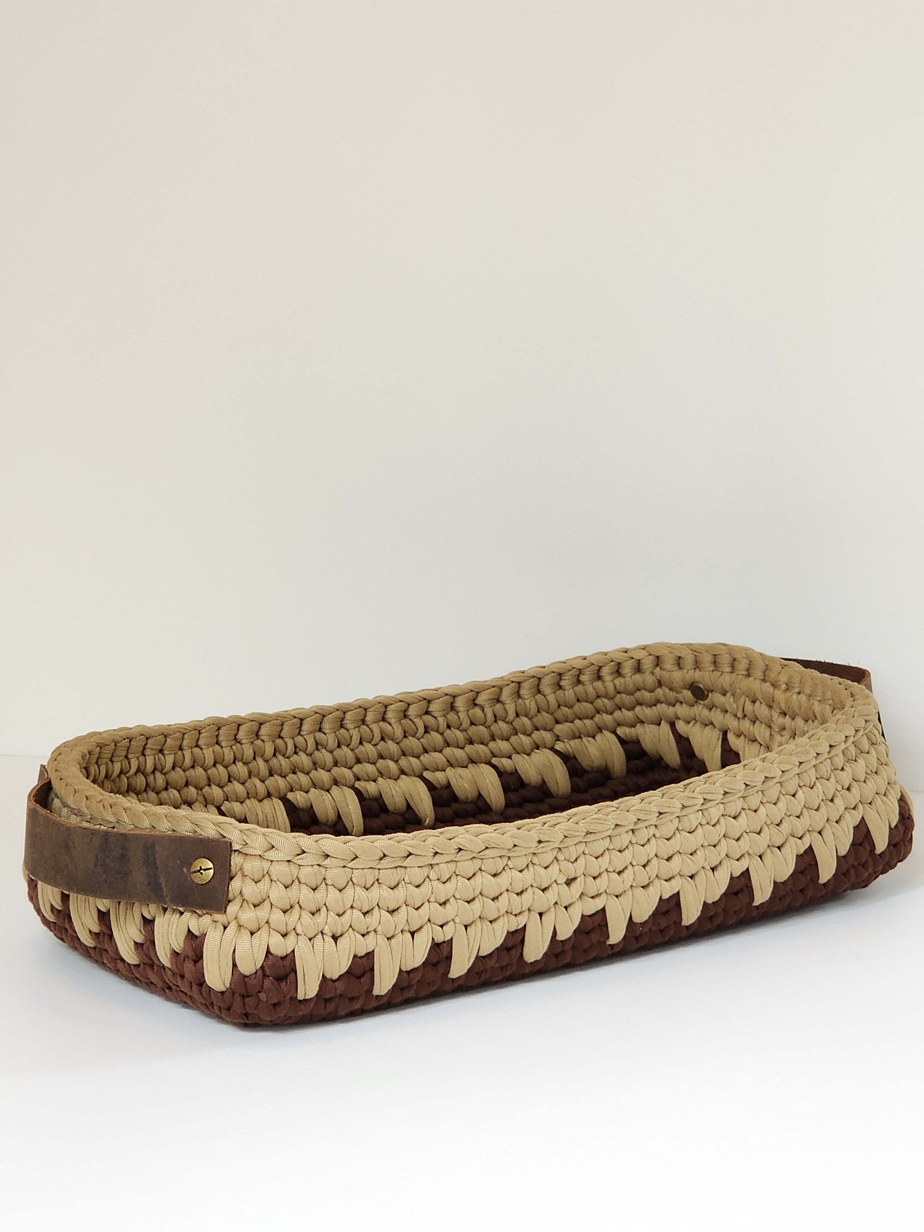 Brown and beige woven basket on a white background