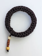 Dark Brawn braided bracelet with wooden beads on a white background