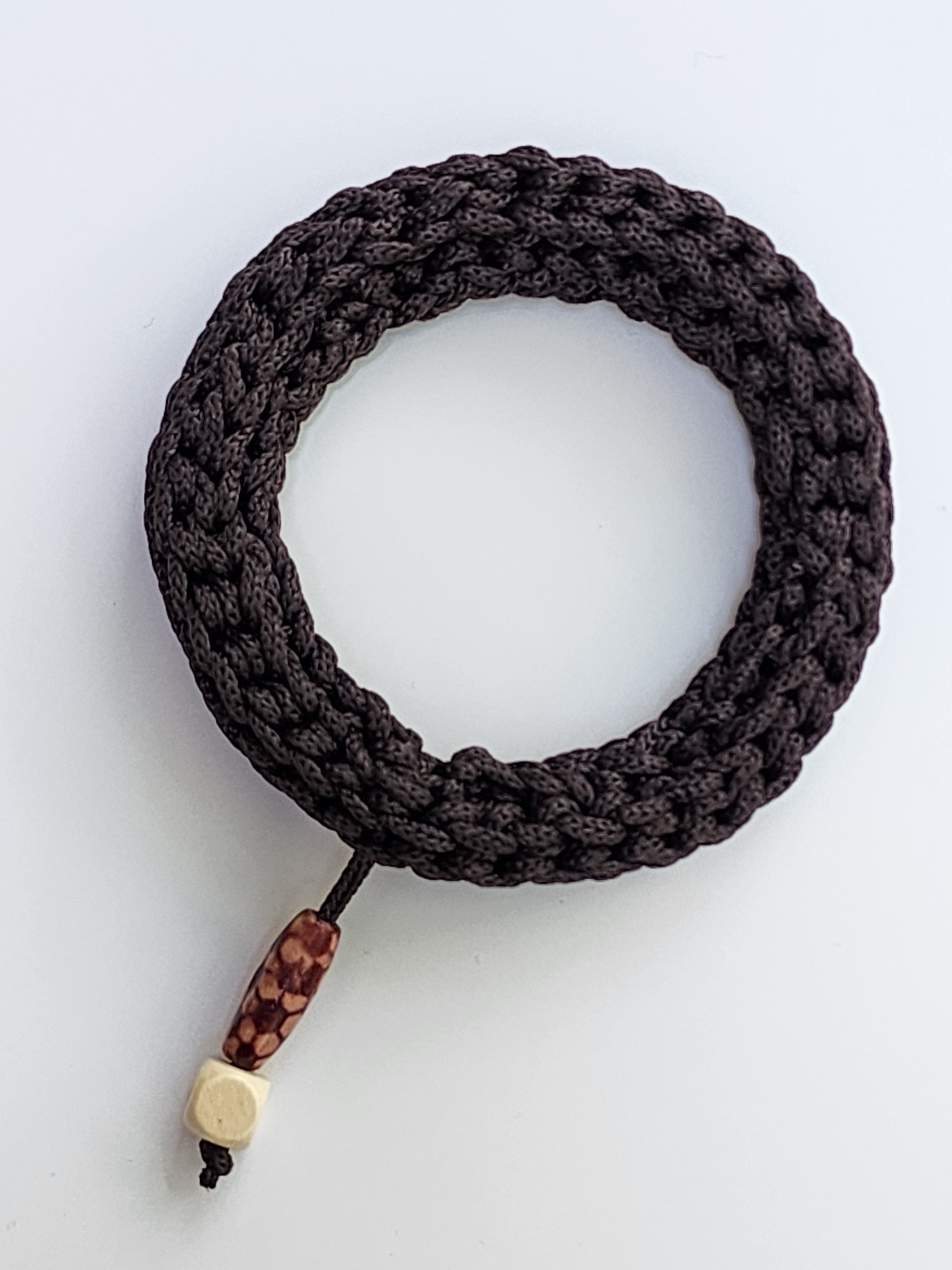 Dark Brawn braided bracelet with wooden beads on a white background